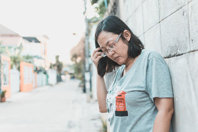 Midsection of woman holding mobile phone while standing outdoors