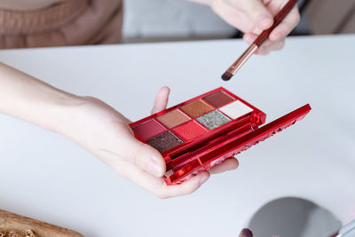 Woman making up with cosmetics set at home. closeup of eyeshadow pallette with vivid colos 