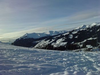 Scenic view of snow covered mountains against sky