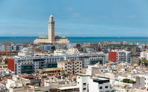 High angle view of townscape by sea against sky