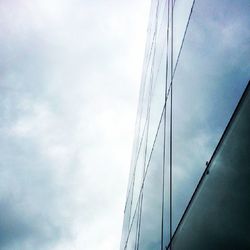 Low angle view of modern building against cloudy sky