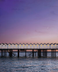 Pier over sea against sky at sunset