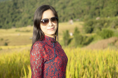 Portrait of smiling woman standing on field