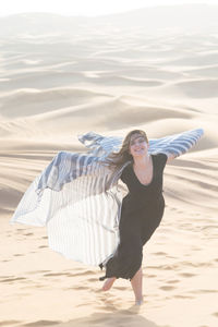 Full length portrait of young woman on beach