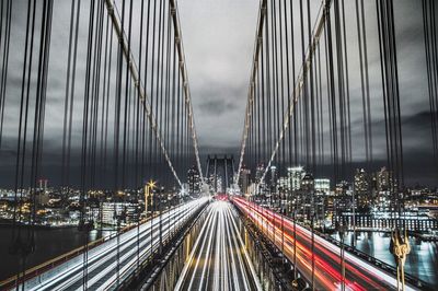 Panoramic view of suspension bridge over city at night