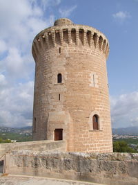 Low angle view of fort against cloudy sky