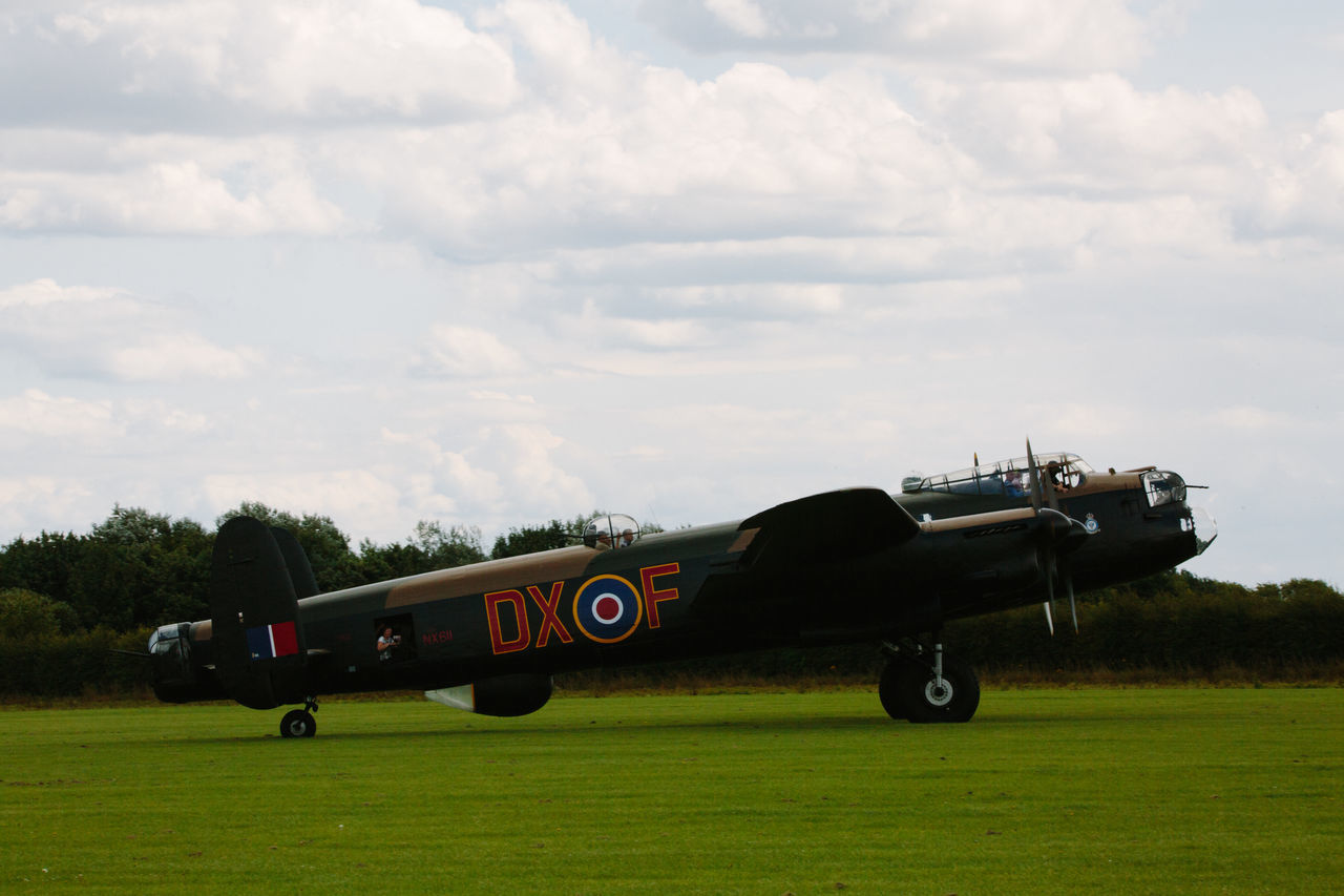 VINTAGE CAR ON FIELD AGAINST SKY