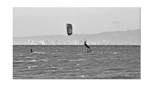 People in sea against sky