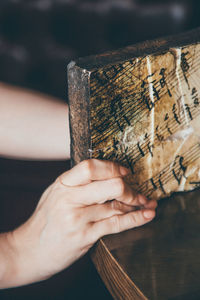 Cropped hand holding weathered wood