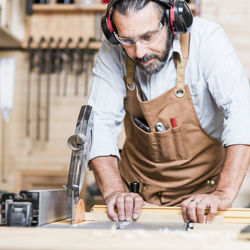 Carpenter listening music while working in workshop