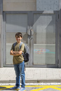 Portrait of boy standing against closed door