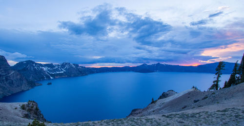 Scenic view of lake by snowcapped mountains against sky