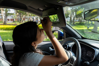 Side view of man driving car