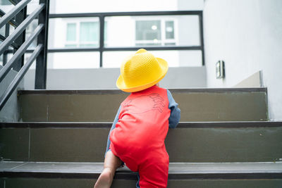 Rear view of boy moving up on staircase