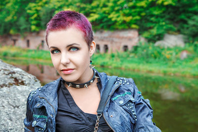 Portrait of hipster woman against lake