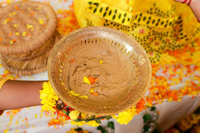 Close-up of hand holding henna tattoo in bowl