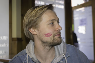 Close-up of man with lipstick mark on face