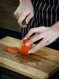 Midsection of person preparing food on cutting board