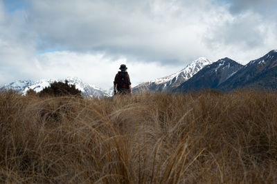 Rear view of person on snowcapped mountain against sky