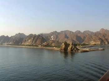 Scenic view of sea and mountains against clear sky