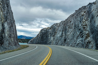 Empty road by mountain against sky