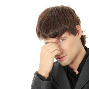 Portrait of young man looking away against white background