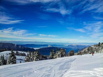 Scenic view of snow covered mountains against blue sky