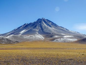 Scenic view of snowcapped mountains against blue sky