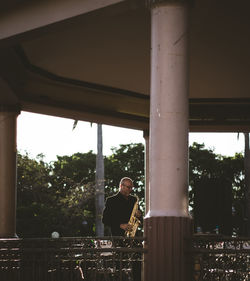 Man standing by bridge