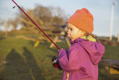 Charming baby fishing in the river at sunset