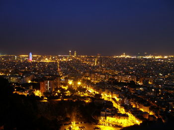 High angle view of illuminated buildings against clear sky at night