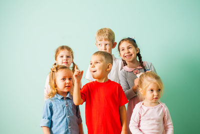 Cute kids standing against wall at home