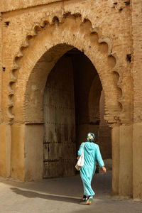 Rear view of woman walking in tunnel