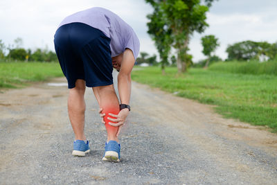 Low section of woman walking on field