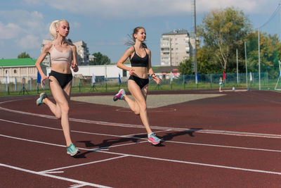 Full length of woman exercising on field