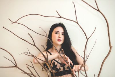 Portrait of beautiful woman standing against wall