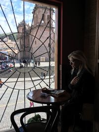 Woman sitting at table by window