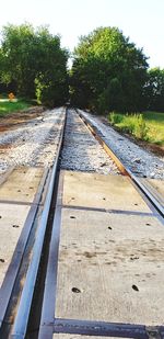 Railroad tracks by trees against sky