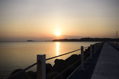 Pier on sea at sunset