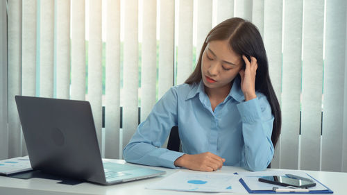 Businesswoman looking at graph in office