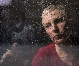 Close-up of woman making heart shape on wet glass