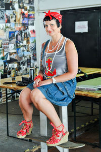 Portrait of smiling woman sitting at tattoo studio