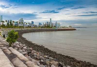 Scenic view of sea by buildings against sky