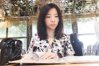 Portrait of young woman sitting on table