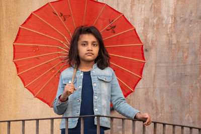 Portrait of woman with umbrella standing in rain