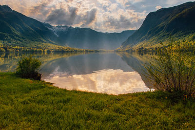 Scenic view of lake by mountains against sky