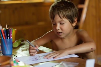 Boy drawing on book
