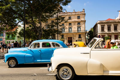 Vintage car on street against building in city