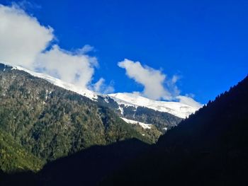 Scenic view of mountains against blue sky