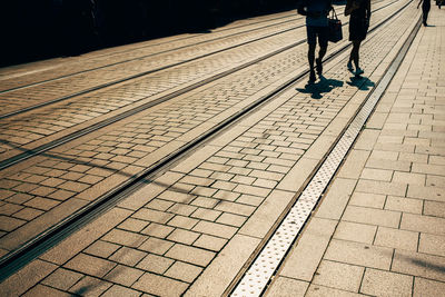 Silhouette of two people walking on street while shopping